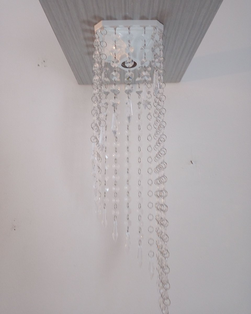 Lustre com fios longos de contas de cristal caindo em cascata