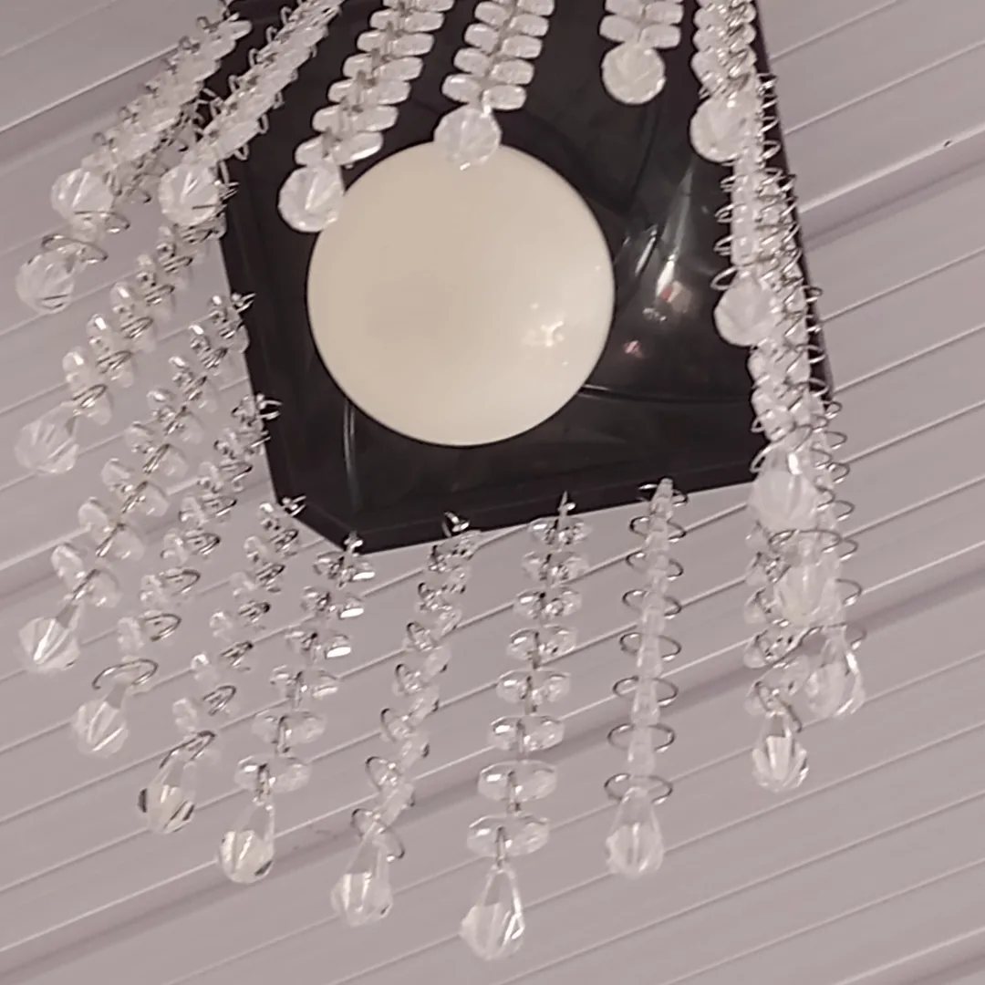 Lustre de base preta com contas de cristal transparente e lâmpada branca